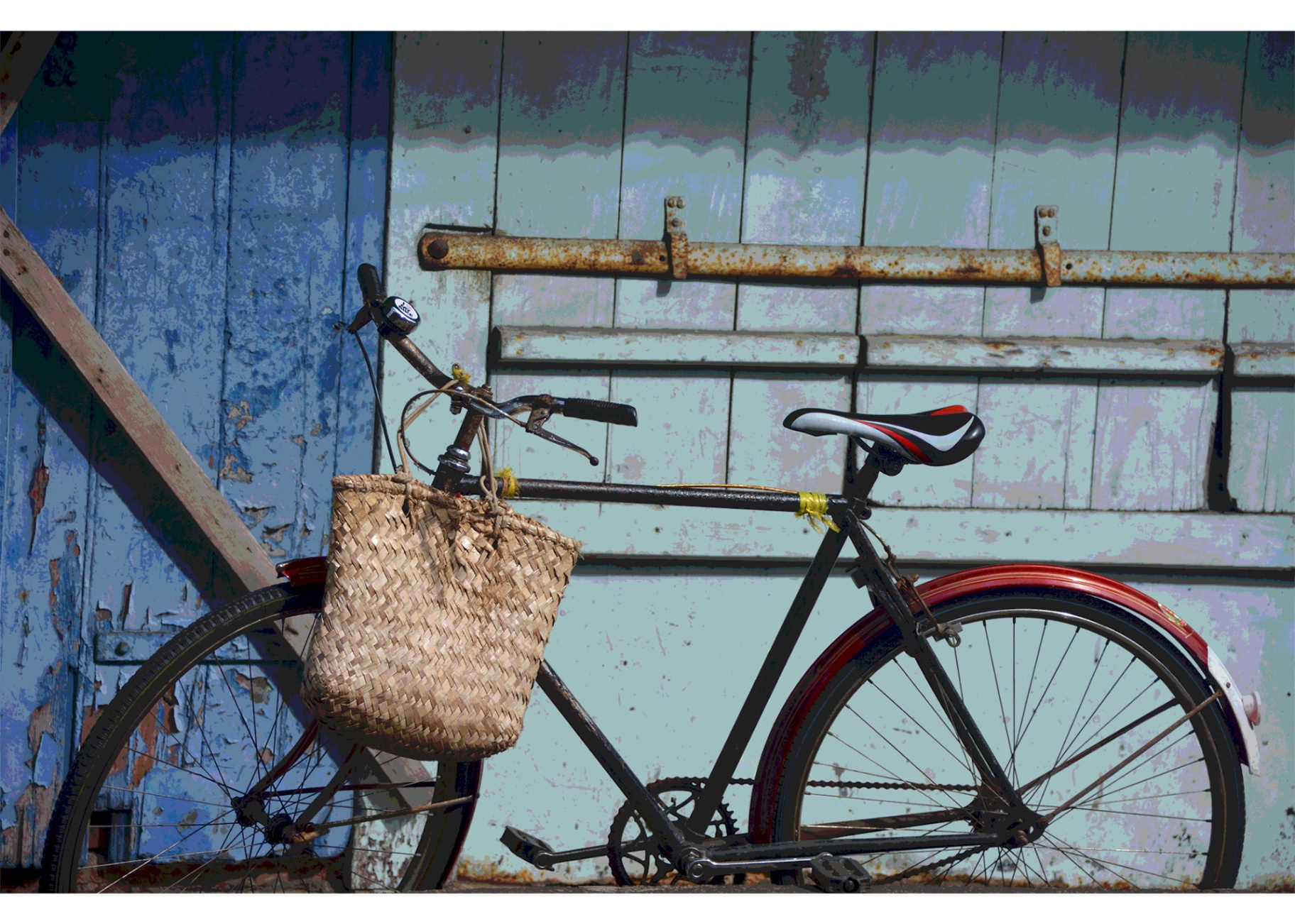 A vintage bicycle resting against a weathered blue wooden wall in Mahébourg, Mauritius